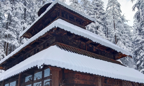 A snow-covered wooden building nestled in a wintry landscape.